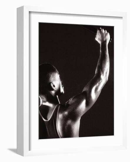 Male Runner Holding Up a Relay Baton-null-Framed Photographic Print