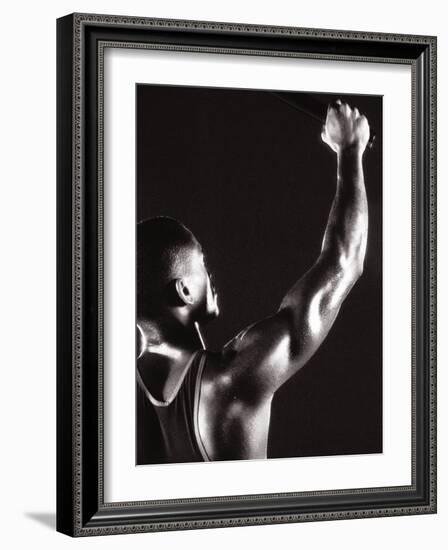 Male Runner Holding Up a Relay Baton-null-Framed Photographic Print