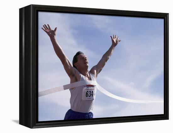 Male Runner Victorious at the Finish Line in a Track Race-null-Framed Premier Image Canvas