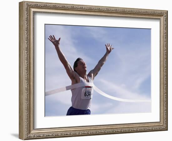 Male Runner Victorious at the Finish Line in a Track Race-null-Framed Photographic Print