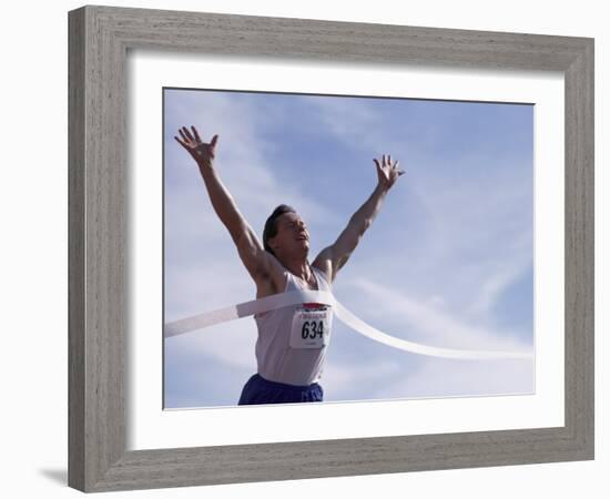 Male Runner Victorious at the Finish Line in a Track Race-null-Framed Photographic Print