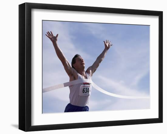 Male Runner Victorious at the Finish Line in a Track Race-null-Framed Photographic Print