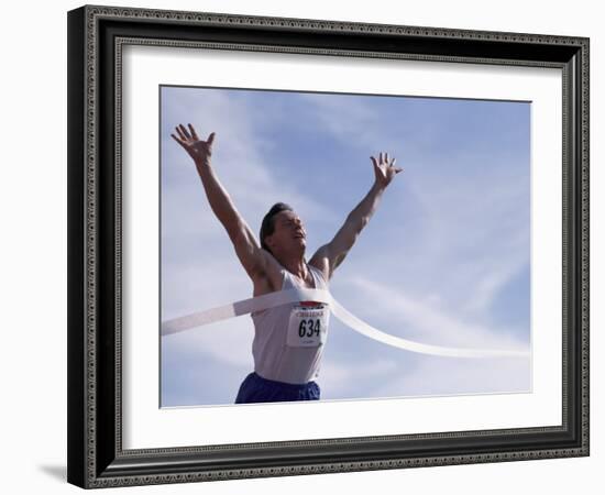 Male Runner Victorious at the Finish Line in a Track Race-null-Framed Photographic Print