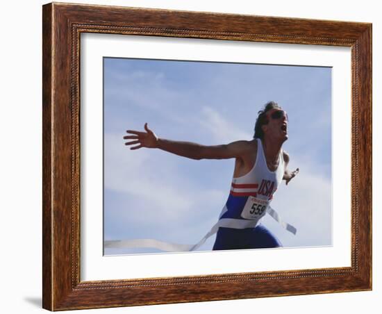 Male Runner Victorious at the Finish Line in a Track Race-null-Framed Photographic Print