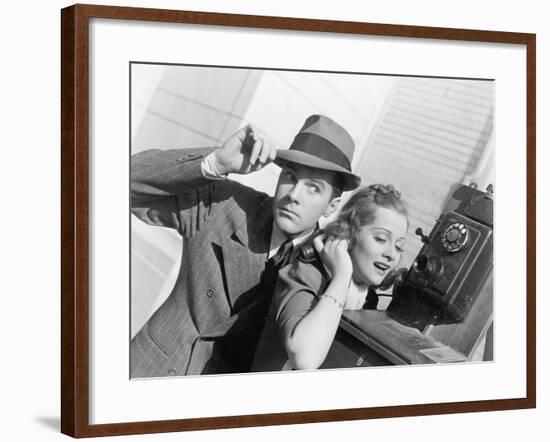 Man and Woman Listening on an Outside Telephone-null-Framed Photo