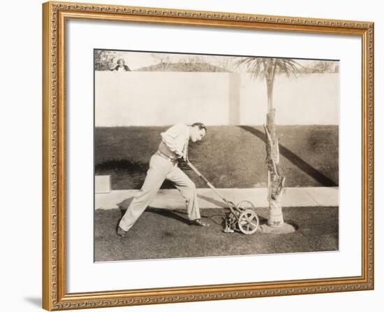 Man Attacking Palm Tree with Lawn Mower-null-Framed Photo