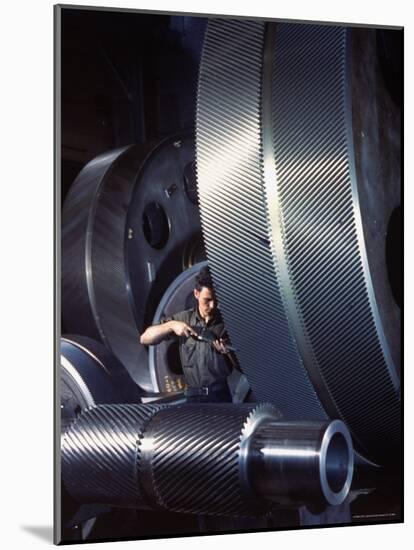 Man Dwarfed by Gigantic Gears He is Working on for the Navy, at General Electric Plant in US-Dmitri Kessel-Mounted Photographic Print