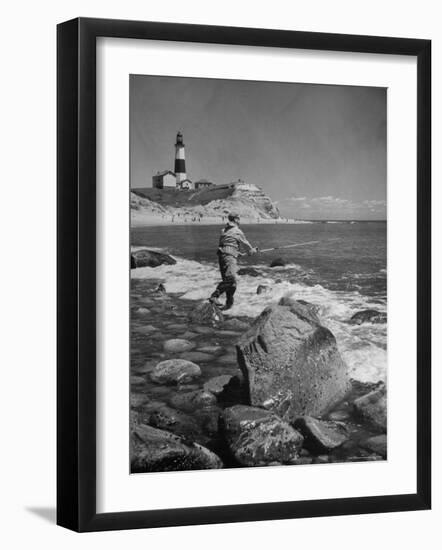 Man Fishing Off Montauk Point. Montauk Lighthouse Visible in Background-Alfred Eisenstaedt-Framed Photographic Print