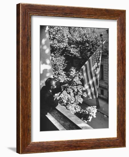 Man Hanging the American Flag Out of the Osteopath's Office Window During WWII-George Strock-Framed Photographic Print