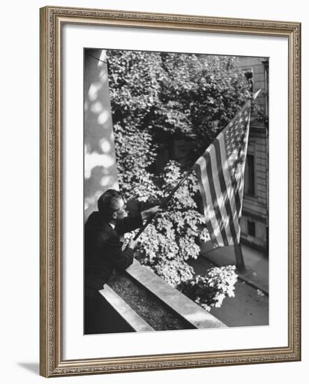 Man Hanging the American Flag Out of the Osteopath's Office Window During WWII-George Strock-Framed Photographic Print