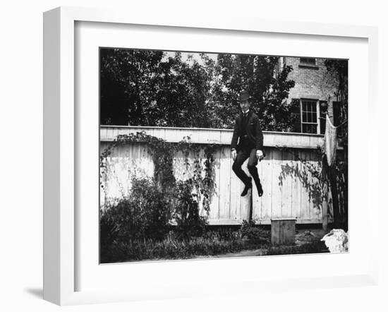 Man in a Suit and Bowler Hat Jumping in the Air in a Backyard in Brooklyn, Ny-Wallace G^ Levison-Framed Photographic Print