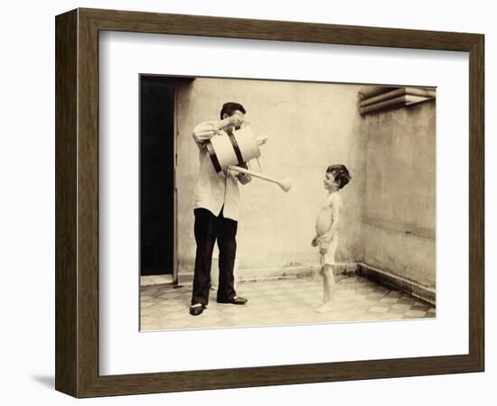 Man Is Sprinkling Boy with Water from Watering Can, 20th Century-Andrew Pitcairn-knowles-Framed Giclee Print