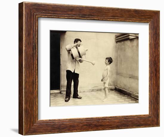 Man Is Sprinkling Boy with Water from Watering Can, 20th Century-Andrew Pitcairn-knowles-Framed Giclee Print