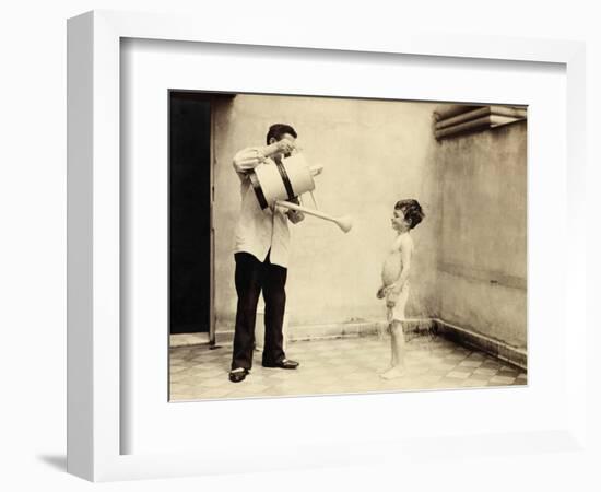 Man Is Sprinkling Boy with Water from Watering Can, 20th Century-Andrew Pitcairn-knowles-Framed Giclee Print