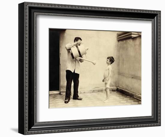 Man Is Sprinkling Boy with Water from Watering Can, 20th Century-Andrew Pitcairn-knowles-Framed Giclee Print