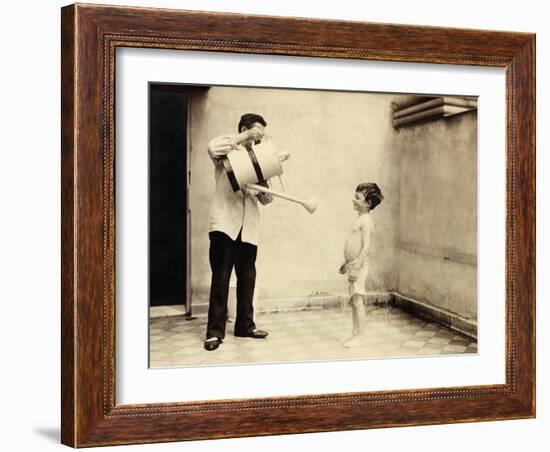 Man Is Sprinkling Boy with Water from Watering Can, 20th Century-Andrew Pitcairn-knowles-Framed Giclee Print