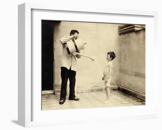 Man Is Sprinkling Boy with Water from Watering Can, 20th Century-Andrew Pitcairn-knowles-Framed Giclee Print