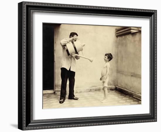 Man Is Sprinkling Boy with Water from Watering Can, 20th Century-Andrew Pitcairn-knowles-Framed Giclee Print