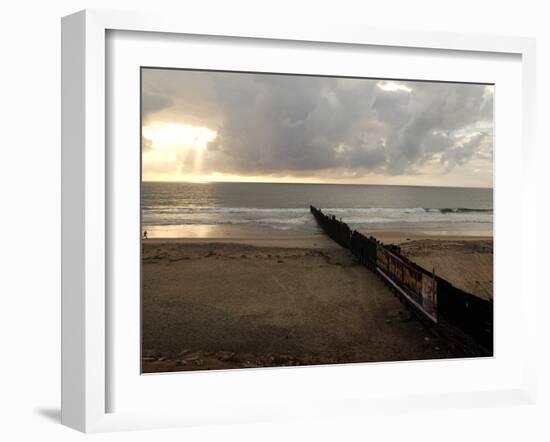 Man Jogs by the Beach Towards the Wall Dividing Mexico and the U.S. in Tijuana, Mexico-null-Framed Photographic Print