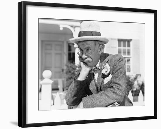 Man Leaning on a Picket Fence Looking into the Distance-null-Framed Photo