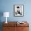 Man Leaning over a Desk with a Ceiling Light Shining on Him-null-Framed Photo displayed on a wall