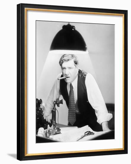 Man Leaning over a Desk with a Ceiling Light Shining on Him-null-Framed Photo