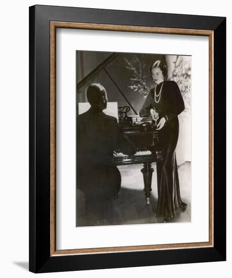 Man Plays a Piano and Looks up at a Glamorous Woman in a Long Dress-null-Framed Photographic Print