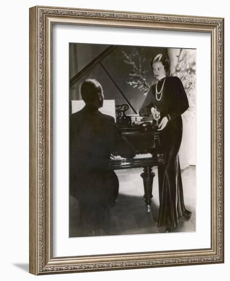 Man Plays a Piano and Looks up at a Glamorous Woman in a Long Dress-null-Framed Photographic Print