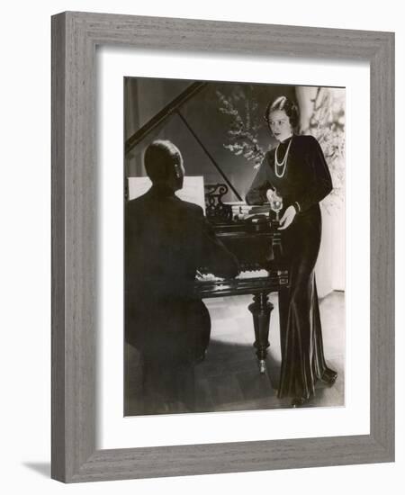 Man Plays a Piano and Looks up at a Glamorous Woman in a Long Dress-null-Framed Photographic Print