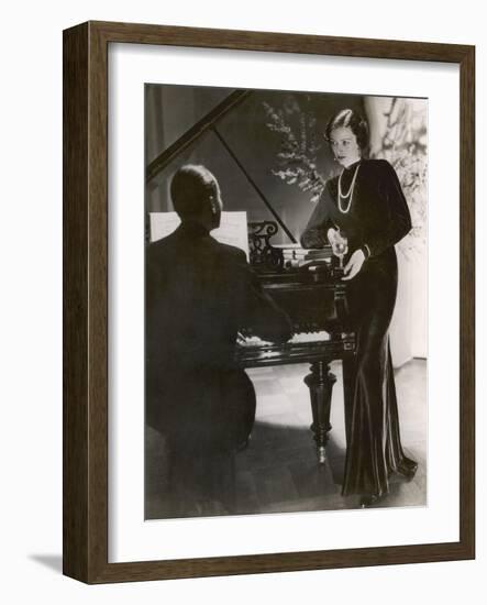 Man Plays a Piano and Looks up at a Glamorous Woman in a Long Dress-null-Framed Photographic Print