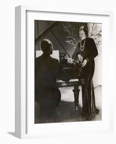 Man Plays a Piano and Looks up at a Glamorous Woman in a Long Dress-null-Framed Photographic Print