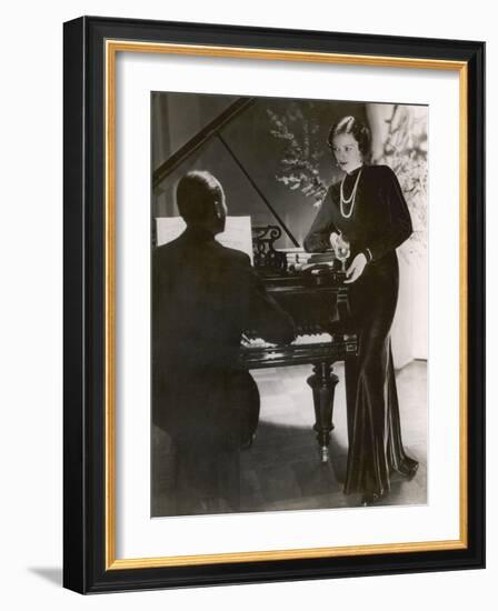 Man Plays a Piano and Looks up at a Glamorous Woman in a Long Dress-null-Framed Photographic Print