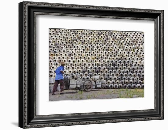 Man pushing cart loaded with wine jars to the big pile in a winery, Zhejiang Province, China-Keren Su-Framed Photographic Print