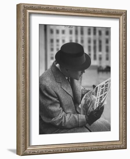 Man Reading a Newspaper While Wearing a Fedora Hat with a Flattened Top and Slim Brim-Ralph Morse-Framed Photographic Print