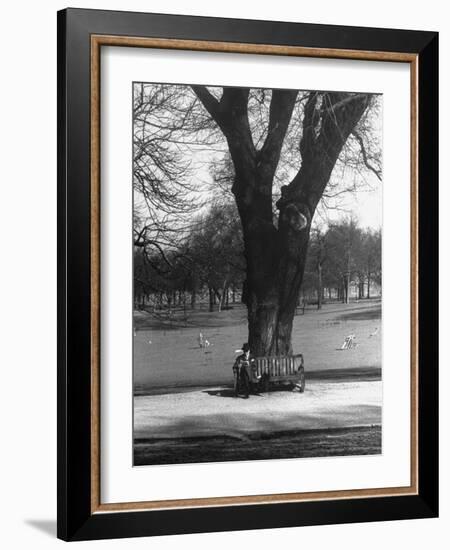 Man Sitting on a Bench and Reading a Newspaper in the Park-Cornell Capa-Framed Photographic Print