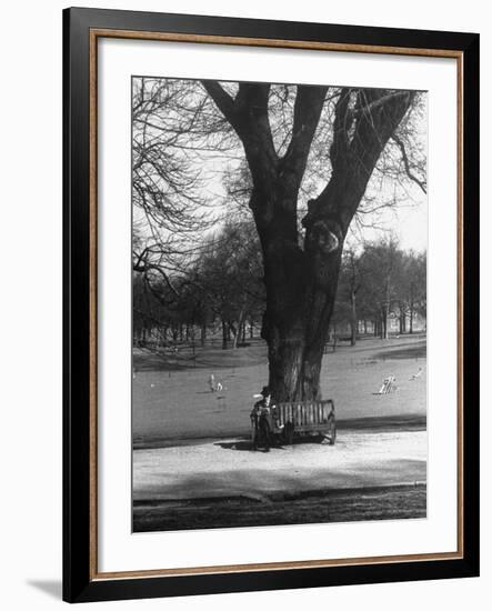 Man Sitting on a Bench and Reading a Newspaper in the Park-Cornell Capa-Framed Photographic Print