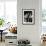 Man Sitting with Oversized Books Holding Sheet Music in His Hands-null-Framed Photo displayed on a wall