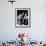 Man Sitting with Oversized Books Holding Sheet Music in His Hands-null-Framed Photo displayed on a wall