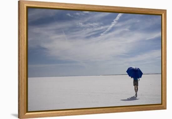 Man Walking With Blue Umbrella On The Bonneville Salt Flats-Lindsay Daniels-Framed Premier Image Canvas