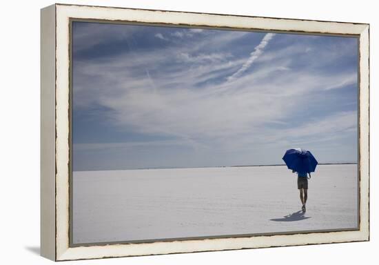 Man Walking With Blue Umbrella On The Bonneville Salt Flats-Lindsay Daniels-Framed Premier Image Canvas