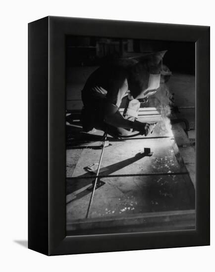 Man Welding Pieces of Metal Together-Allan Grant-Framed Premier Image Canvas