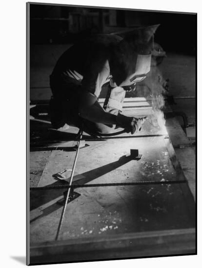 Man Welding Pieces of Metal Together-Allan Grant-Mounted Photographic Print