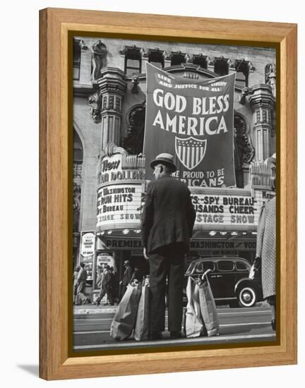 Man with Shopping Bags in Front of Million Dollar Theatre Emblazoned with God Bless America Banner-Bob Landry-Framed Premier Image Canvas