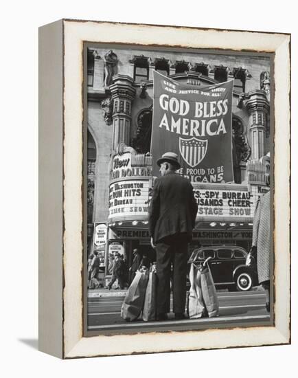 Man with Shopping Bags in Front of Million Dollar Theatre Emblazoned with God Bless America Banner-Bob Landry-Framed Premier Image Canvas