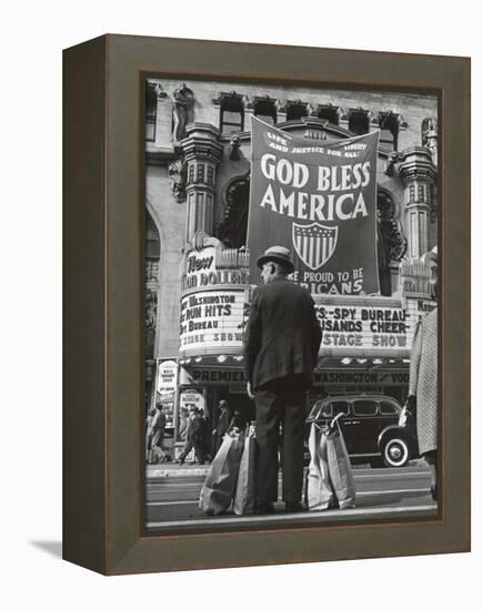 Man with Shopping Bags in Front of Million Dollar Theatre Emblazoned with God Bless America Banner-Bob Landry-Framed Premier Image Canvas