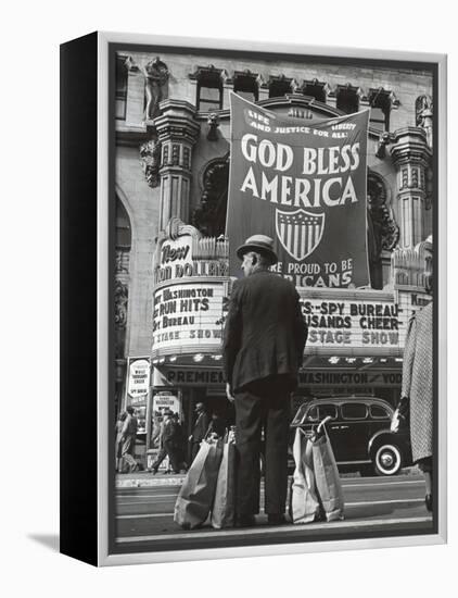 Man with Shopping Bags in Front of Million Dollar Theatre Emblazoned with God Bless America Banner-Bob Landry-Framed Premier Image Canvas