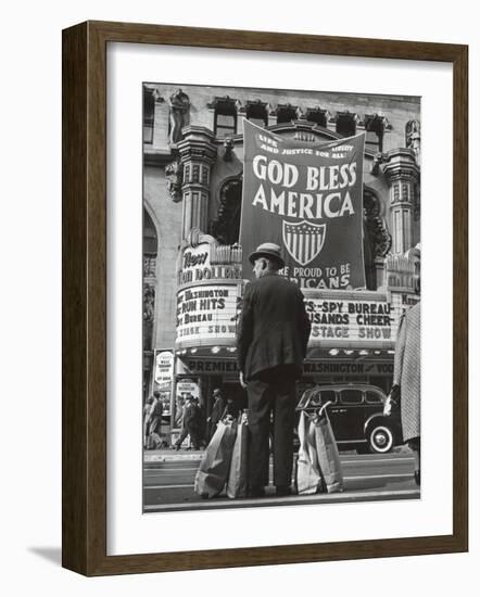 Man with Shopping Bags in Front of Million Dollar Theatre Emblazoned with God Bless America Banner-Bob Landry-Framed Photographic Print