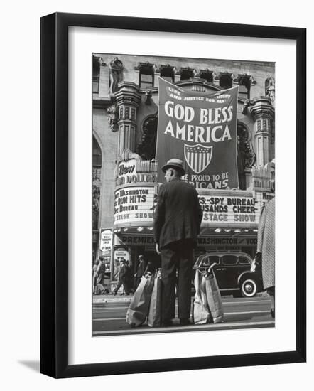 Man with Shopping Bags in Front of Million Dollar Theatre Emblazoned with God Bless America Banner-Bob Landry-Framed Photographic Print