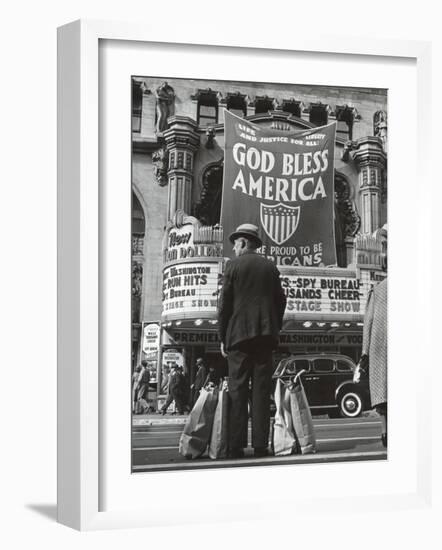 Man with Shopping Bags in Front of Million Dollar Theatre Emblazoned with God Bless America Banner-Bob Landry-Framed Photographic Print