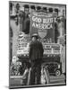 Man with Shopping Bags in Front of Million Dollar Theatre Emblazoned with God Bless America Banner-Bob Landry-Mounted Photographic Print